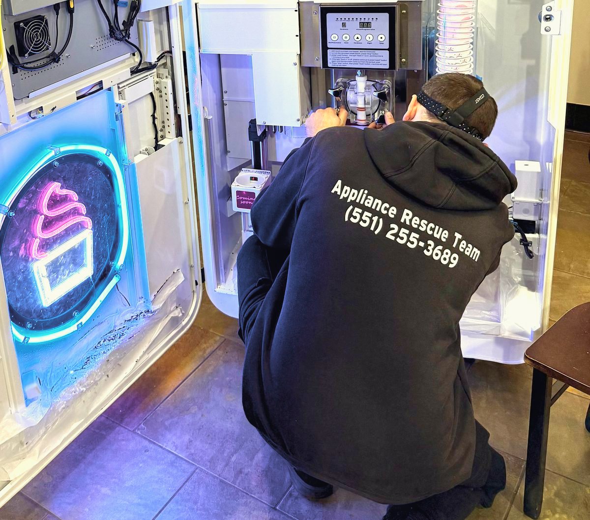 Appliance Rescue Team technician in a branded sweatshirt working on an appliance — Appliance Rescue Team serves Dumont, NJ