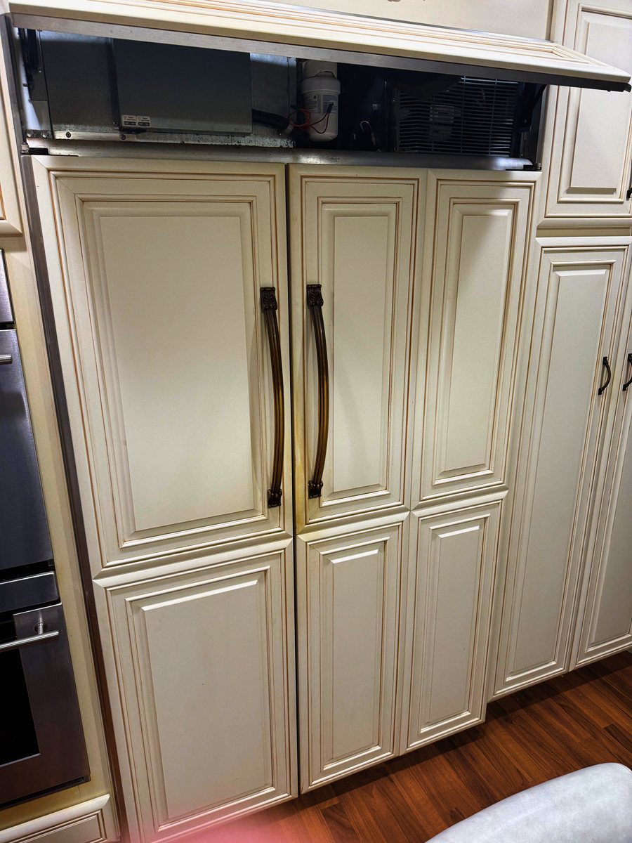 Built-in refrigerator with its upper service panel open during a repair visit — Appliance Rescue Team serves Norwood, NJ