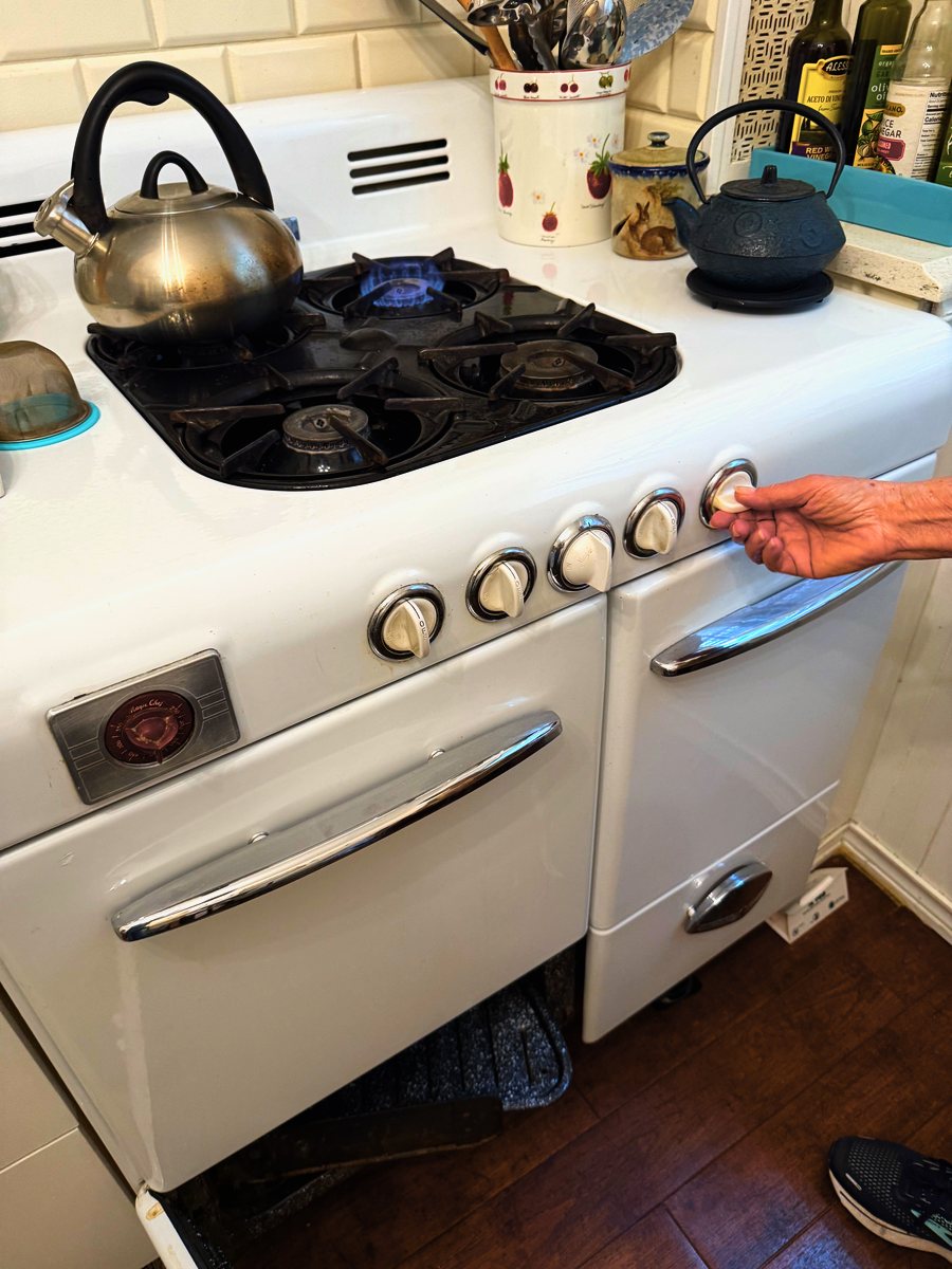 Appliance Rescue Team technician testing a burner on a vintage gas range after repair — Appliance Rescue Team serves Cresskill, NJ