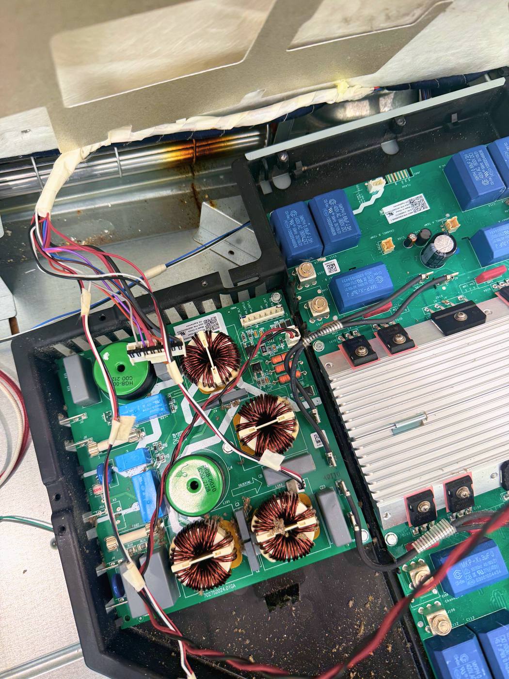 The generator board in its tray between the coils — the one part every zone on the cooktop depends on