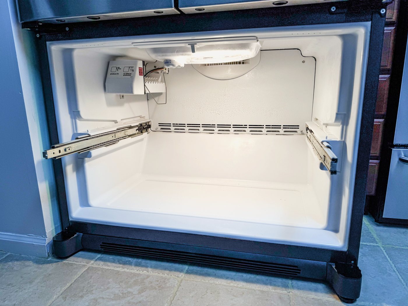 The freezer drawer open. On this design the evaporator and its fan sit behind the rear wall of this compartment