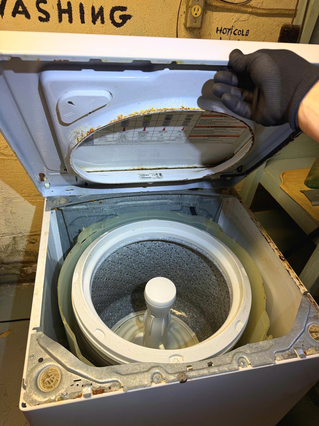 The Kenmore top-loader opened up. The wash tub hangs inside the cabinet rather than sitting on anything
